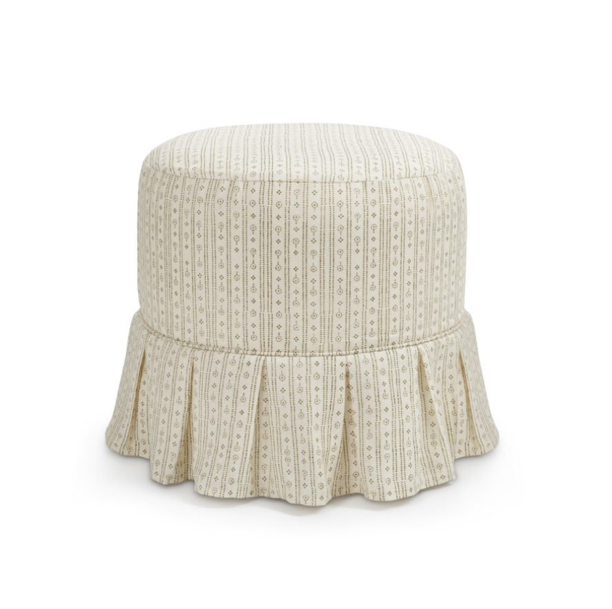 A round upholstered ottoman with a box pleat ruffled skirt, featuring a vertical stripe pattern in cream and beige with small geometric motifs, shown against a plain white background.