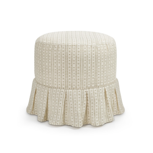 A round upholstered ottoman with a box pleat ruffled skirt, featuring a vertical stripe pattern in cream and beige with small geometric motifs, shown against a plain white background.