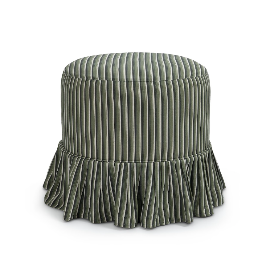 A round slipcover upholstered ottoman or stool with vertical channel tufting and a ruffled skirt base, shown on a clean white background.