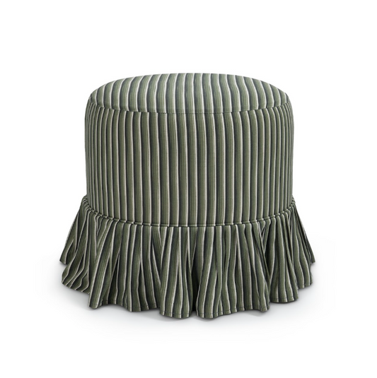 A round slipcover upholstered ottoman or stool with vertical channel tufting and a ruffled skirt base, shown on a clean white background.